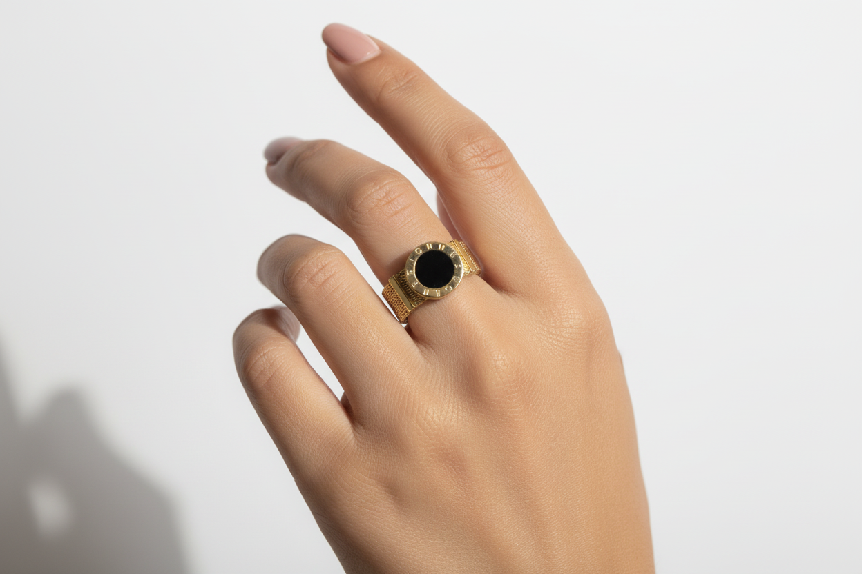 Female model wearing gold mesh ring with black stone
