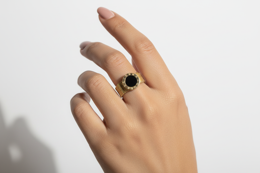 Female model wearing gold mesh ring with black stone